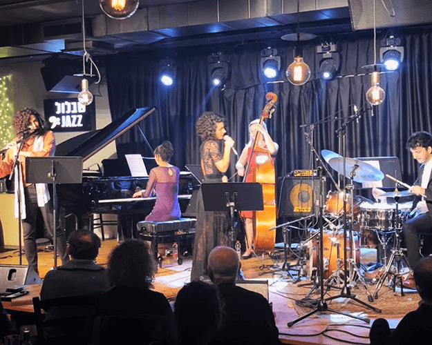 A stellar line-up of jazz musicians grace the stage at Shablul Jazz Club, during a night honoring women in music. Featuring Chen Levy (vocals), Hila Kolik (piano), Anbar Paz (bass), Hadar Noiberg (flute), and David Sirkis (drums).